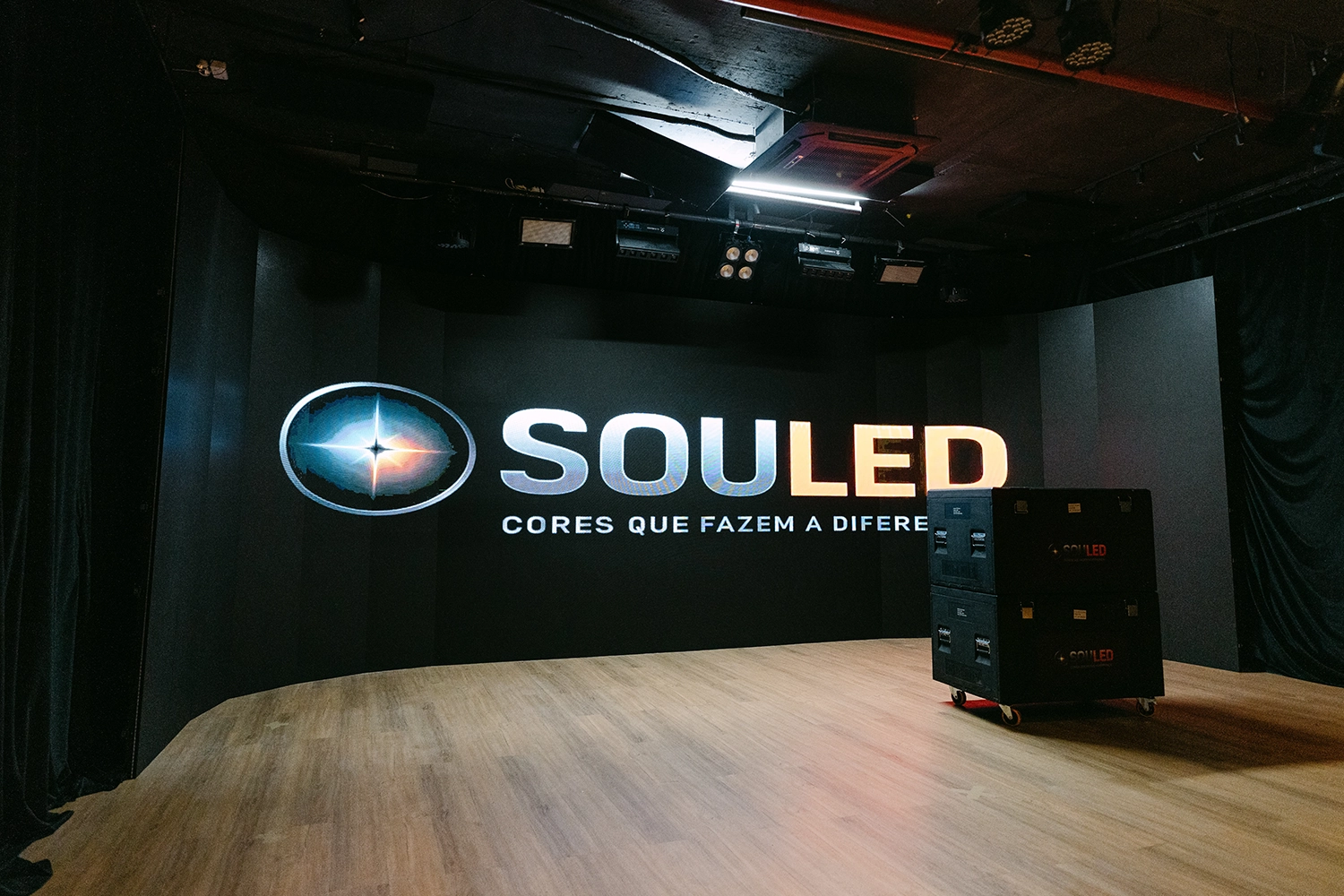 Visão do estúdio com piso de madeira, painel SouLed e equipamentos